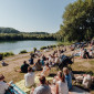 Menschen schauen dem Taufgottesdienst zu